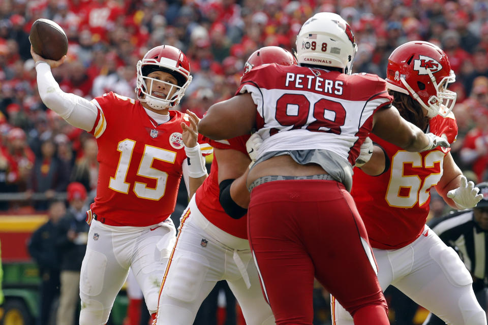 Kansas City Chiefs quarterback Patrick Mahomes (15) throws a touchdown pass to wide receiver Tyreek Hill as offensive lineman Andrew Wylie (77) blocks Arizona Cardinals defensive tackle Corey Peters (98) during the first half of an NFL football game in Kansas City, Mo., Sunday, Nov. 11, 2018. (AP Photo/Charlie Riedel)