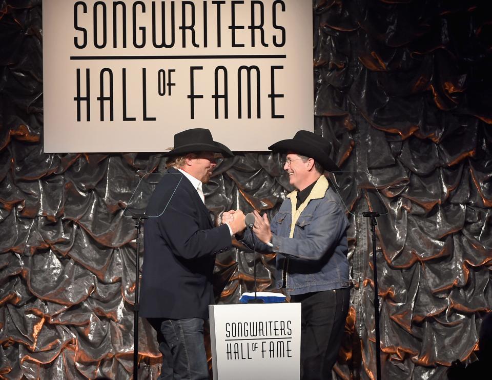 Toby Keith and Stephen Colbert speak onstage at the Songwriters Hall of Fame in 2015. The singer died Monday after stomach cancer battle