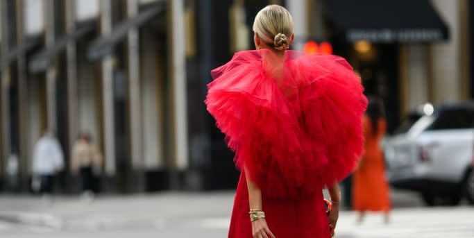 new york, new york september 12 leonie hanne wears gold earrings, a red short dress with oversized ruffled tulle shoulder, a gold juste un clou bracelet from cartier, a gold and silver watch, gold rings, a silver bracelet, a black glitter with gold metallic borders clutch, black shiny varnished leather heels sandals  shoes , outside carolina herrera, during new york fashion week, on september 12, 2022 in new york city photo by edward berthelotgetty images