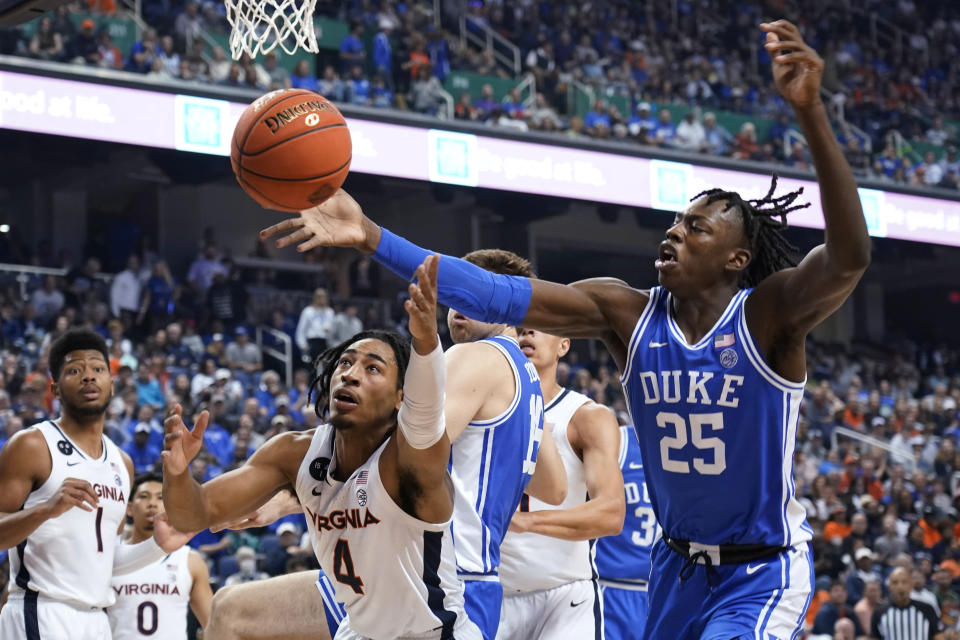 Duke forward Mark Mitchell (25) grabs a rebound next to Virginia guard Armaan Franklin (4) during the second half of an NCAA college basketball game for the championship of the men's Atlantic Coast Conference Tournament in Greensboro, N.C., Saturday, March 11, 2023. (AP Photo/Chuck Burton)