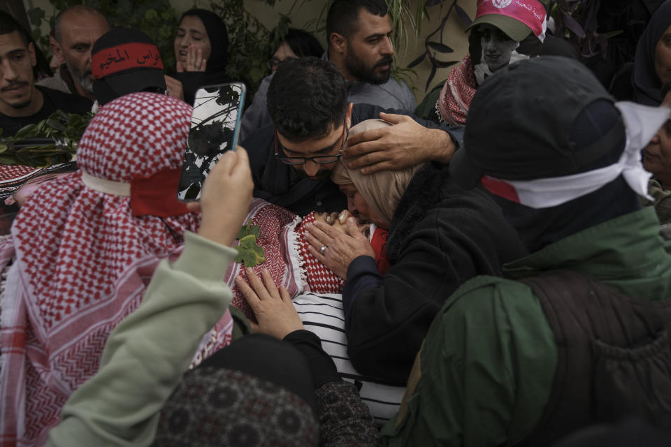 Palestinian mourners carry the body of Omar Manaa during his funeral in the West Bank refugee camp of Deheishe near Bethlehem, Monday, Dec. 5, 2022. Palestinian health officials say Manaa, a 22-year-old Palestinian man, was killed by Israeli fire during a military raid in the occupied West Bank. The army said it opened fire after a crowd attacked soldiers with stones and firebombs. (AP Photo/Mahmoud Illean)