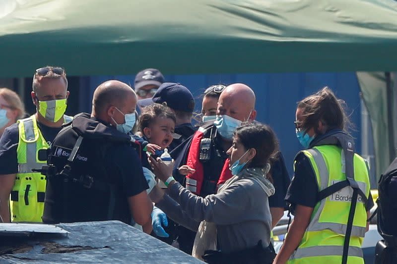 FILE PHOTO: A migrant woman reunites with her child after arriving at Dover harbour, in Dover