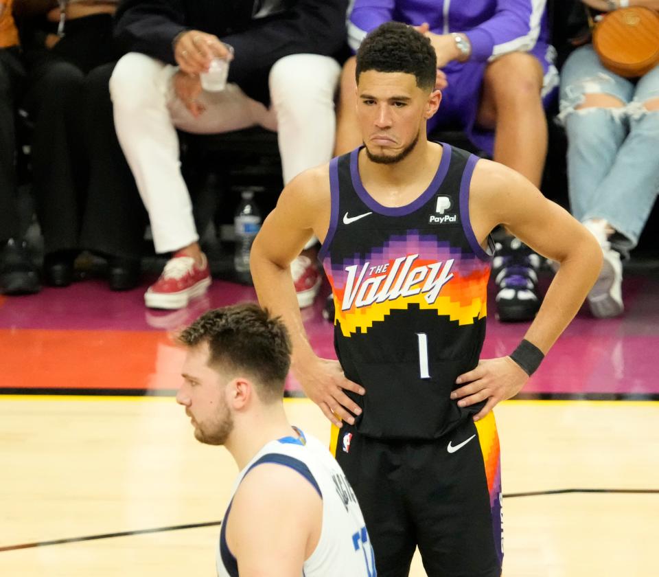 May 15, 2022; Phoenix, Ariz..U.S.; Phoenix Suns guard Devin Booker (1) makes a face after Dallas Mavericks guard Luka Doncic (77) made a basket and was fouled during game 7 of the Western Conference semifinals at Footprint Center.