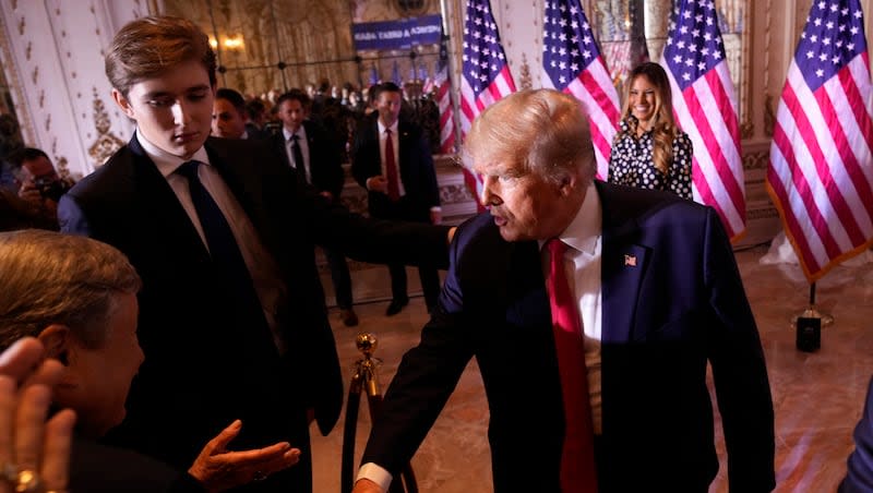 Former President Donald Trump greets people after announcing he is running for president for the third time as he speaks at Mar-a-Lago in Palm Beach, Tuesday, Nov. 15, 2022. Son Barron Trump watches.