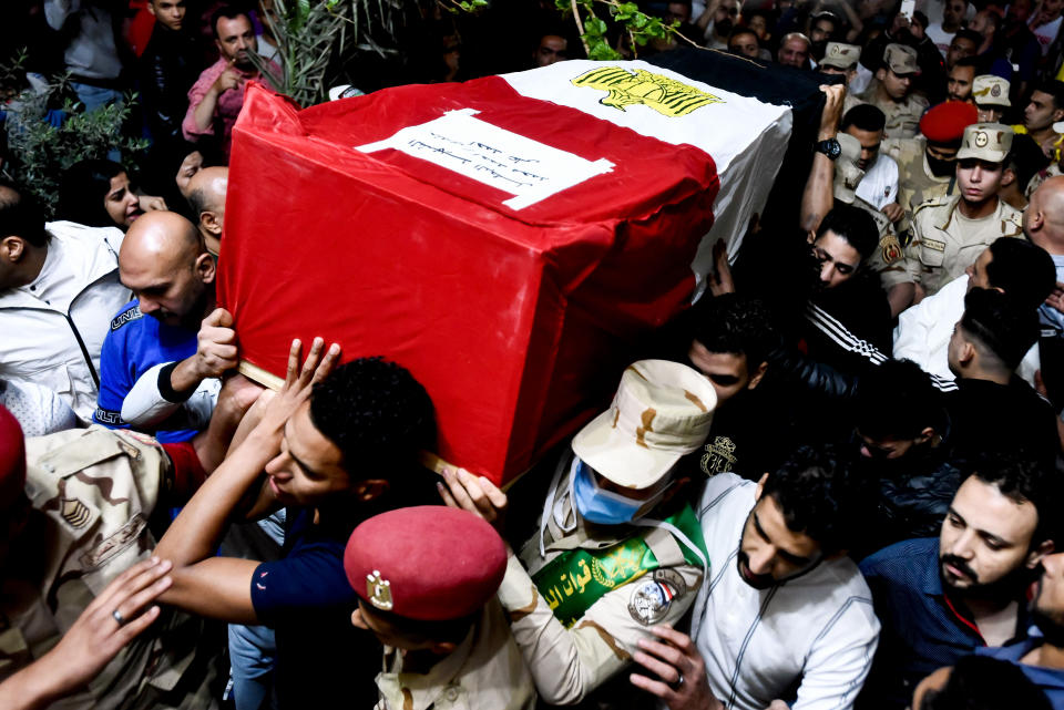 Men carry the coffin of military solider Ahmed Mohamed Ahmed Ali, who was killed in battle, during his funeral service, in Qalyubia province, Egypt, Sunday, May 8, 2022. At least 11 Egyptian troops, including an officer, were killed Saturday, May 7, 2022 in a militant attack on a water pumping station east of the Suez Canal, the military said. (AP Photo/Sayed Hassan)