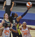 Dallas Wings guard Arike Ogunbowale scores over Connecticut Sun defenders DeWanna Bonner (24) and Emma Cannon (32) during a WNBA basketball game Tuesday, June 22, 2021, at Mohegan Sun Arena in Uncasville, Conn. (Sean D. Elliot/The Day via AP)