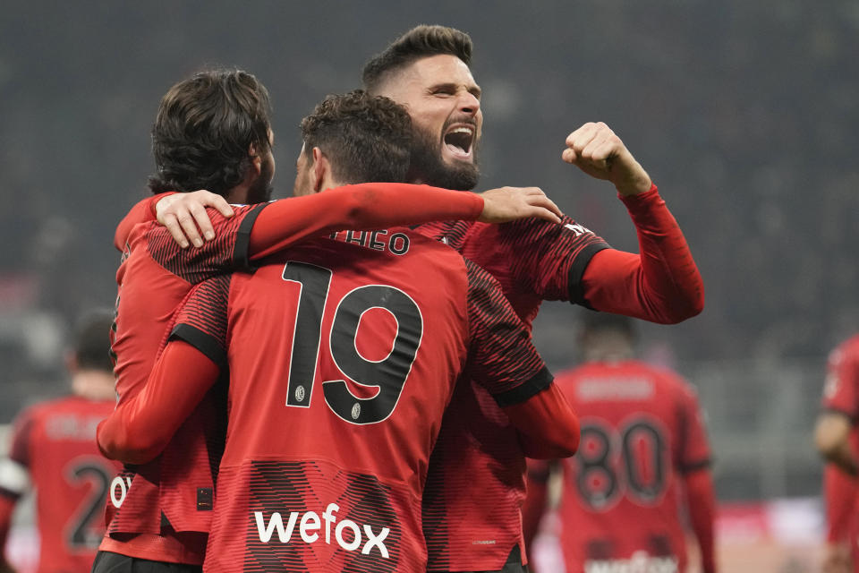 Théo Hernández del AC Milán (centro) celebra con Olivier Giroud (derecha) y Yacine Adlir luego de anotar el tercer gol para su equipo en el partido de la Liga de Italia ante la Roma en el estadio San Siro, en Milán, Italia, el domingo 14 de enero de 2024. (AP Foto/Luca Bruno)