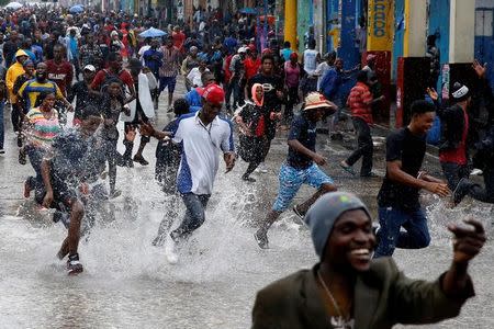 Supporters of Fanmi Lavalas political party splash around in water on a flooded street as they take part in a gathering while Hurricane Matthew passes in Port-au-Prince, Haiti, October 4, 2016. REUTERS/Carlos Garcia Rawlins