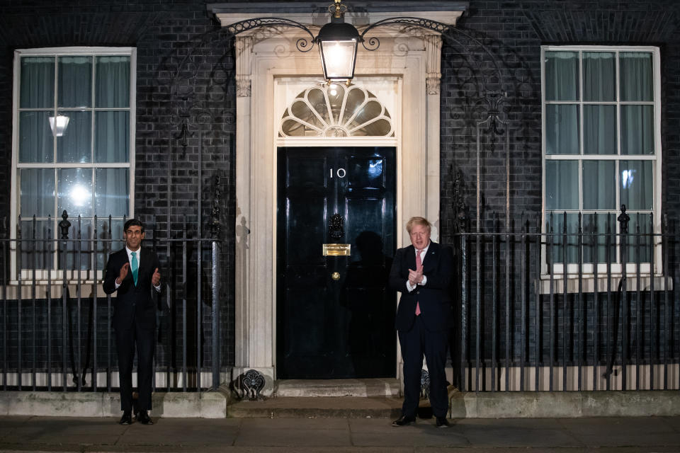 Prime Minister Boris Johnson (right) and Chancellor Rishi Sunak outside 10 Downing Street, London, joining in with a national applause for the NHS to show appreciation for all NHS workers who are helping to fight the Coronavirus. (Photo by Aaron Chown/PA Images via Getty Images)