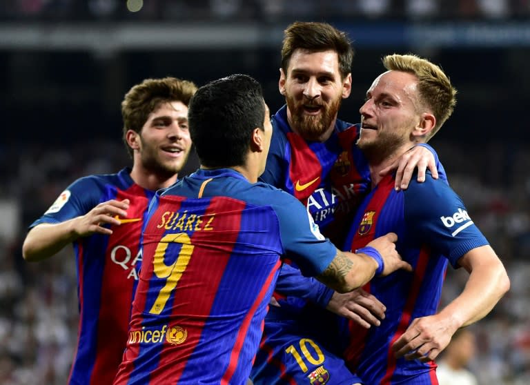 Barcelona's midfielder Ivan Rakitic (R) celebrates a goal with Lionel Messi (2ndR) and Luis Suarez (2ndL) during a Spanish league football match against Real Madrid on April 23, 2017