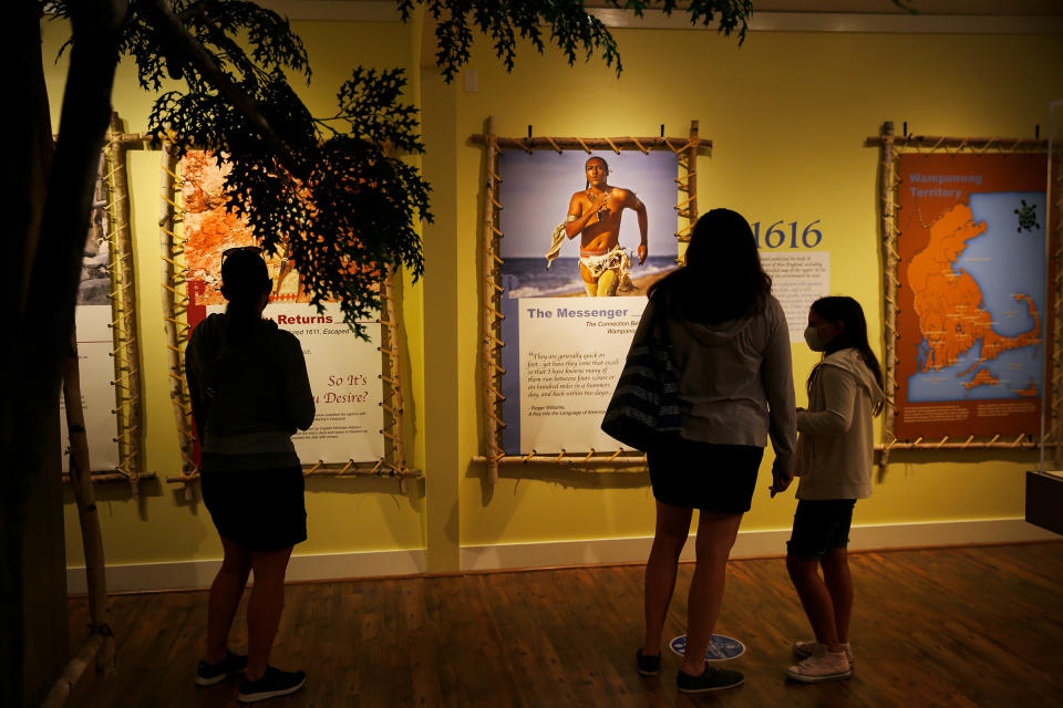 Visitors to the Pilgrim Monument and Provincetown Museum pause to examine a new exhibit about early interactions between the Pilgrims and the Wampanoag tribe in Provincetown, MA on Aug. 27.<span class="copyright">Jessica Rinaldi—The Boston Globe/Getty Images</span>