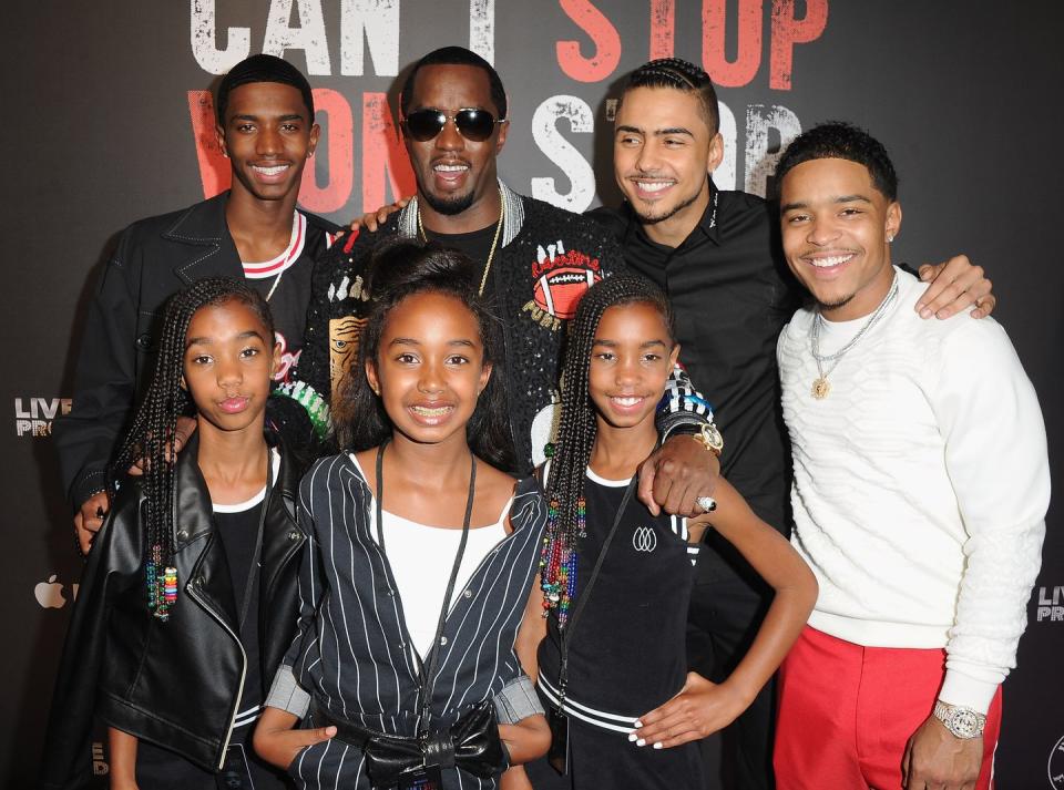 sean combs stands and smiles with six of his children