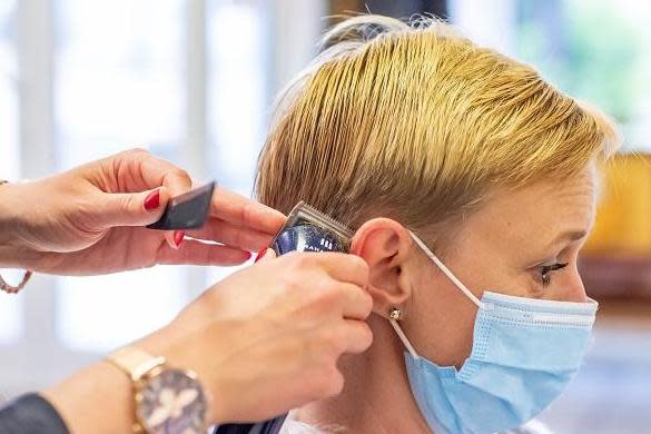Hair salons have re-opened in Germany, and customers and hairdressers wear protective masks: Getty Images