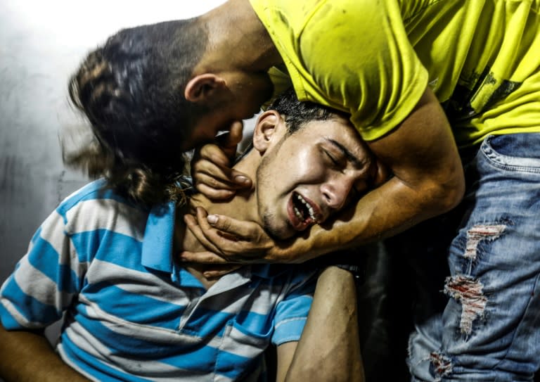 Palestinian youths mourn at al-Shifa hospital morgue on July 14, 2018 after two teenagers were killed in one of a series of Israeli raids