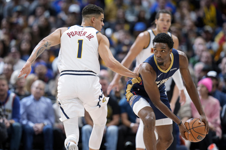 New Orleans Pelicans forward Herbert Jones, right, looks to pass the ball as Denver Nuggets forward Michael Porter Jr. (1) defends in the first half of an NBA basketball game on Monday, Nov. 6, 2023, in Denver. (AP Photo/David Zalubowski)