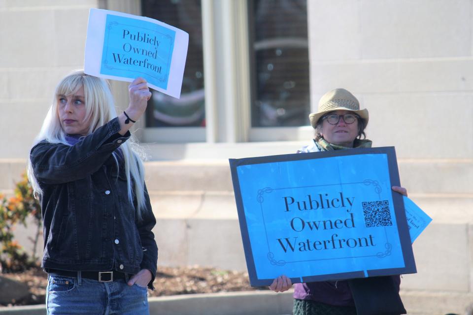 Holland residents hold signs along River Avenue on Wednesday, April 26, advocating against the May 2 land sale ballot proposal.