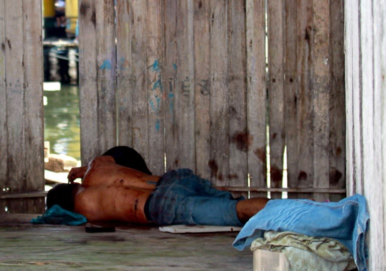 A Sulu gunmen who was shot dead, lies on the ground after a shoot-out with soldiers in Simunul village on March 4, 2013. Malaysia vowed to beef up security in the eastern state where at least 26 people have been reported killed after a bizarre invasion by Philippine followers of a self-styled sultan. AFP PHOTO MALAYSIA OUT