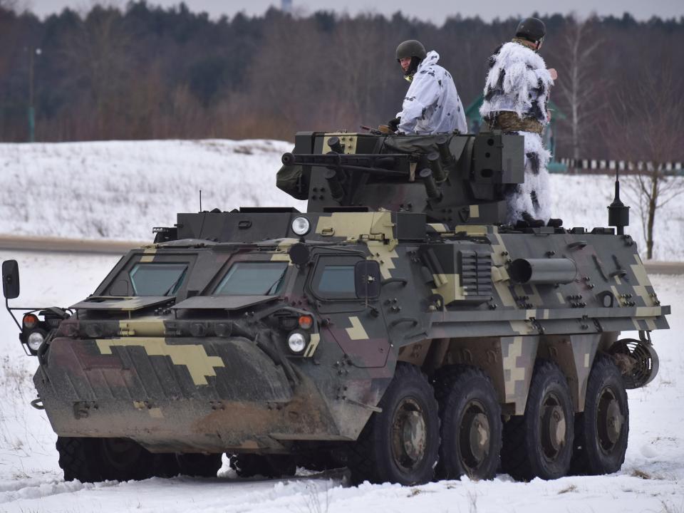 LVIV, UKRAINE - 2022/02/04: Ukrainian soldiers ride on top of the BTR-4 "Bucephalus" during the weapons training exercise at the training ground at the International Center for Peacekeeping and Security