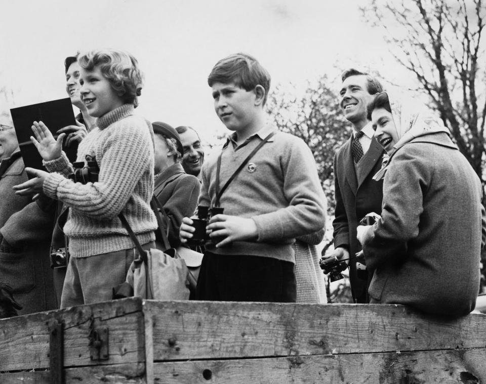 Queen Elizabeth II sits on a cart with  Prince Charles and Princess Anne at the cross-country race during the Horse Trials in Badminton on April 22, 1960.