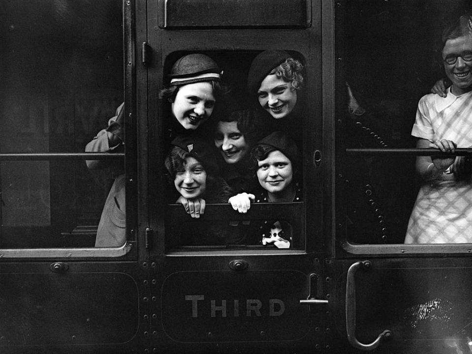 Employees of Messrs Carreras peer out of their railway carriage window prior to departure from Charing Cross Station, London, in 1934.