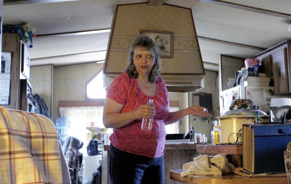 In this photo made on Tuesday, April 10, 2012, Janet McIntyre talks about the water from her well between drinks from some commercially bottled water, in her home in Evans City, Pa. McIntyre, whose home is near a gas well drilled using the hydraulic fracturing process, said doctors told her not to drink or bathe in the water after test results showed traces of chemicals. She lives in one of ten households in a neighborhood 30 miles north of Pittsburgh, where residents feel nearby drilling has impacted their water. State and industry experts say tests have shown the water is fine. (AP Photo/Keith Srakocic)