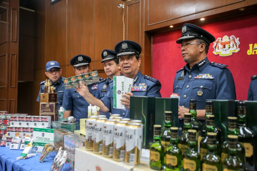 Perak Customs director Mohamad Sarpin poses with seized contraband cigarettes and alcohol worth over RM2 million during a press conference in Ipoh February 25, 2020. — Picture by Farhan Najib