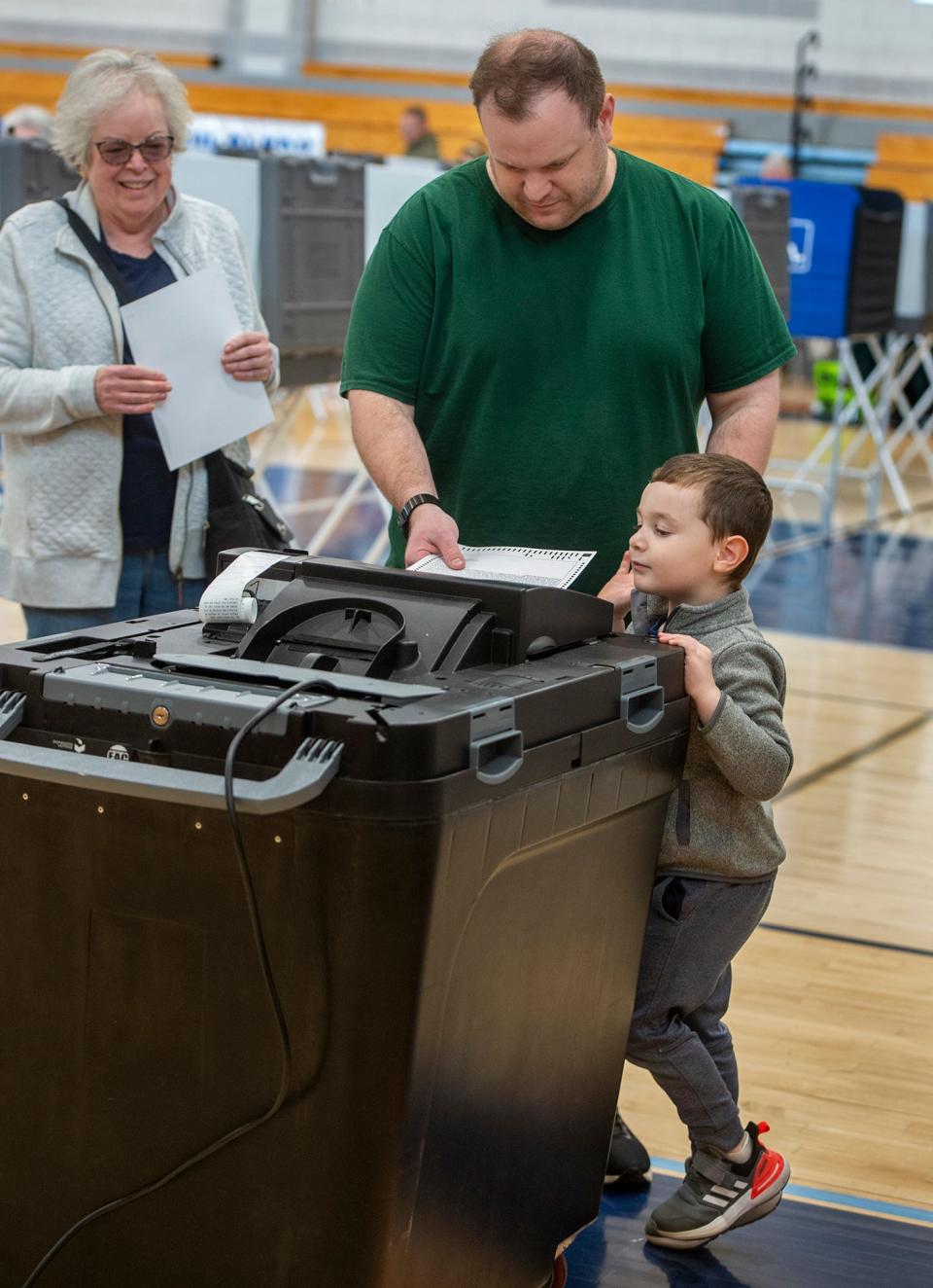 Cole Pithis, 4, of Franklin, watches as his father, Mike Pithis, cast his ballot inside the Franklin High School gym in a special election asking voters to fund construction of a new Tri-County Regional Vocational Technical High School, Oct. 24, 2023.