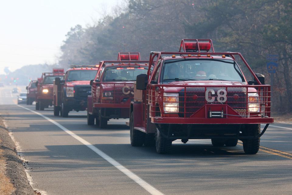 New Jersey State Forest Service trucks drive west along Route 539 near Forge Road heading towards a forest fire in Little Egg Harbor Tuesday afternoon, March 7, 2023.