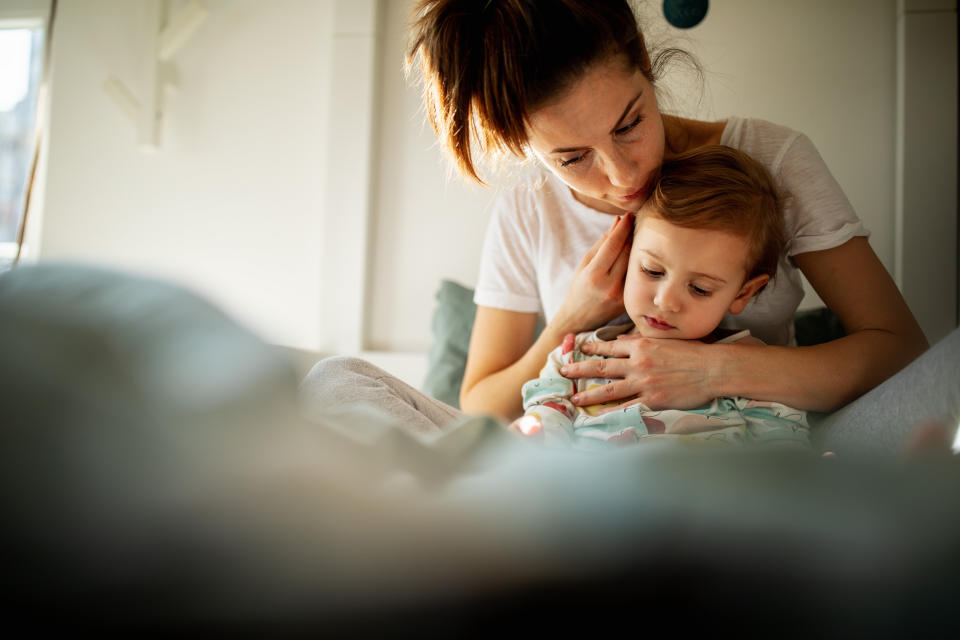 A woman lovingly holds and looks at a toddler in a cozy, comfortable environment