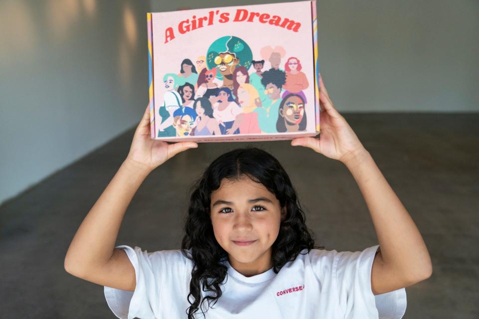 Lily Rodriguez, 11, hoists up a A Girl's Dream STEAM kit she received a few weeks prior at the Mexicantown Community Development Corporation in Detroit Wednesday, Aug. 10, 2022. A Girl's Dream has created an after-school and weekend program with the goal of engaging young women of color in STEAM (Science, Technology, Engineering, Arts and Math) fields. The group has made kits that include a variety of project-oriented activities including paints and chia seeds etc.