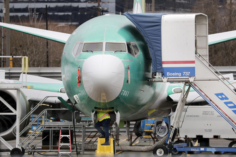 FILE - In this Dec. 16, 2019, file photo, a worker looks up underneath a Boeing 737 MAX jet, in Renton, Wash. Boeing has found a new software problem on its grounded 737 Max jetliner. The aircraft maker said, Friday, Jan. 17, 2020, it is making the necessary changes and working with the Federal Aviation Administration. (AP Photo/Elaine Thompson, File)
