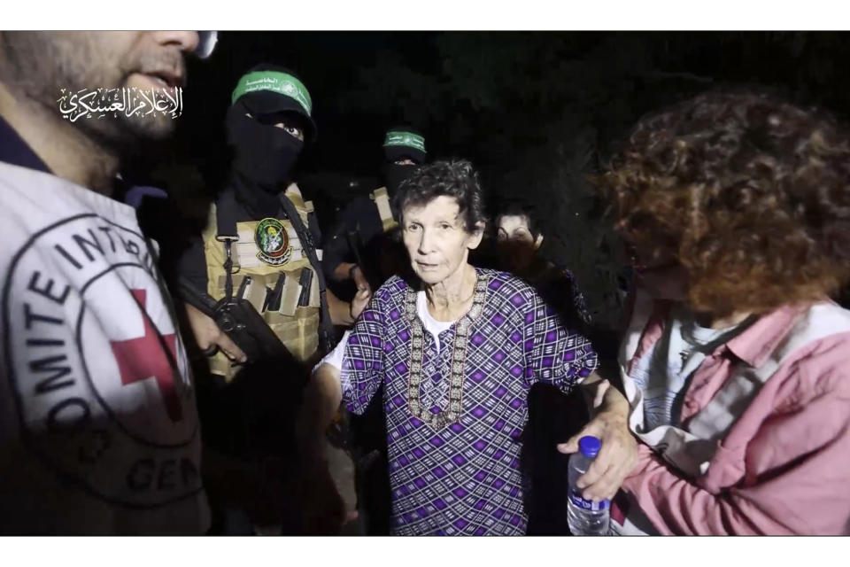 This image taken from video released by Al Qassam brigades on its Telegram channel, shows Yocheved Lifshitz, 85, shaking hands a thanking a member of Hamas as she is released to the Red Cross in an unknown location, Monday, Oct. 23, 2023. (Al Qassam brigades via AP)