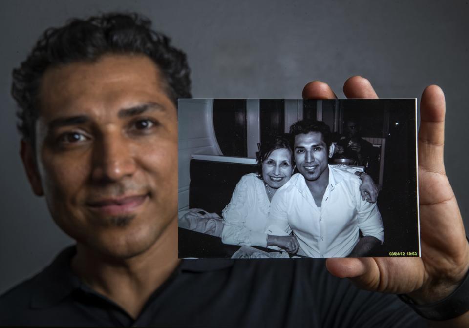 Disney character designer José Zelaya holds a photograph taken in 2012 of him and his mother, Degni Garcia Menendez.