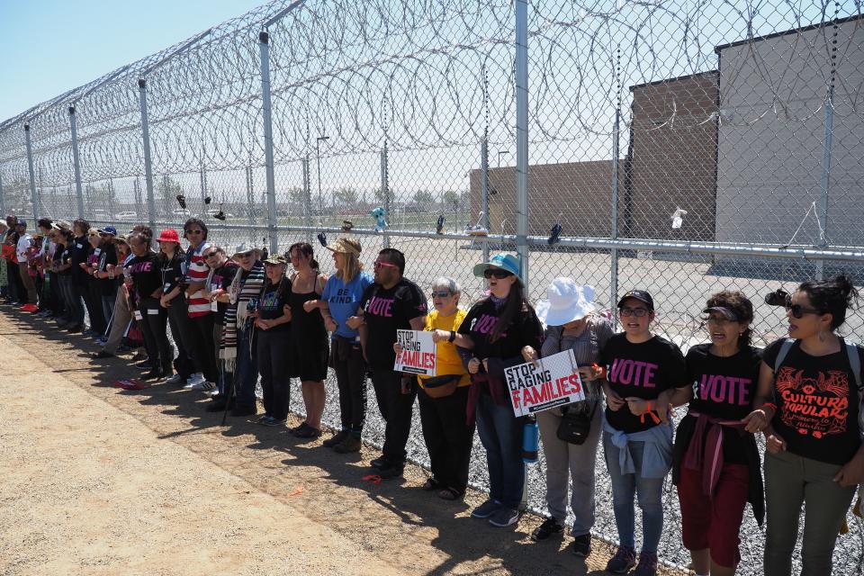 Protestors link arms after tying children's shoes and keys on the fence outside the Otay Mesa  Detention Center during a demonstration against US immigration policy that separates children from parents, in San Diego, California June 23, 2018. - The Otay Mesa Detention Center, owned and operated by private prison company CoreCivic, has an inmate population that includes detainees of the U.S. Immigration and Customs Enforcement agency. (Photo by Robyn Beck / AFP)        (Photo credit should read ROBYN BECK/AFP/Getty Images)