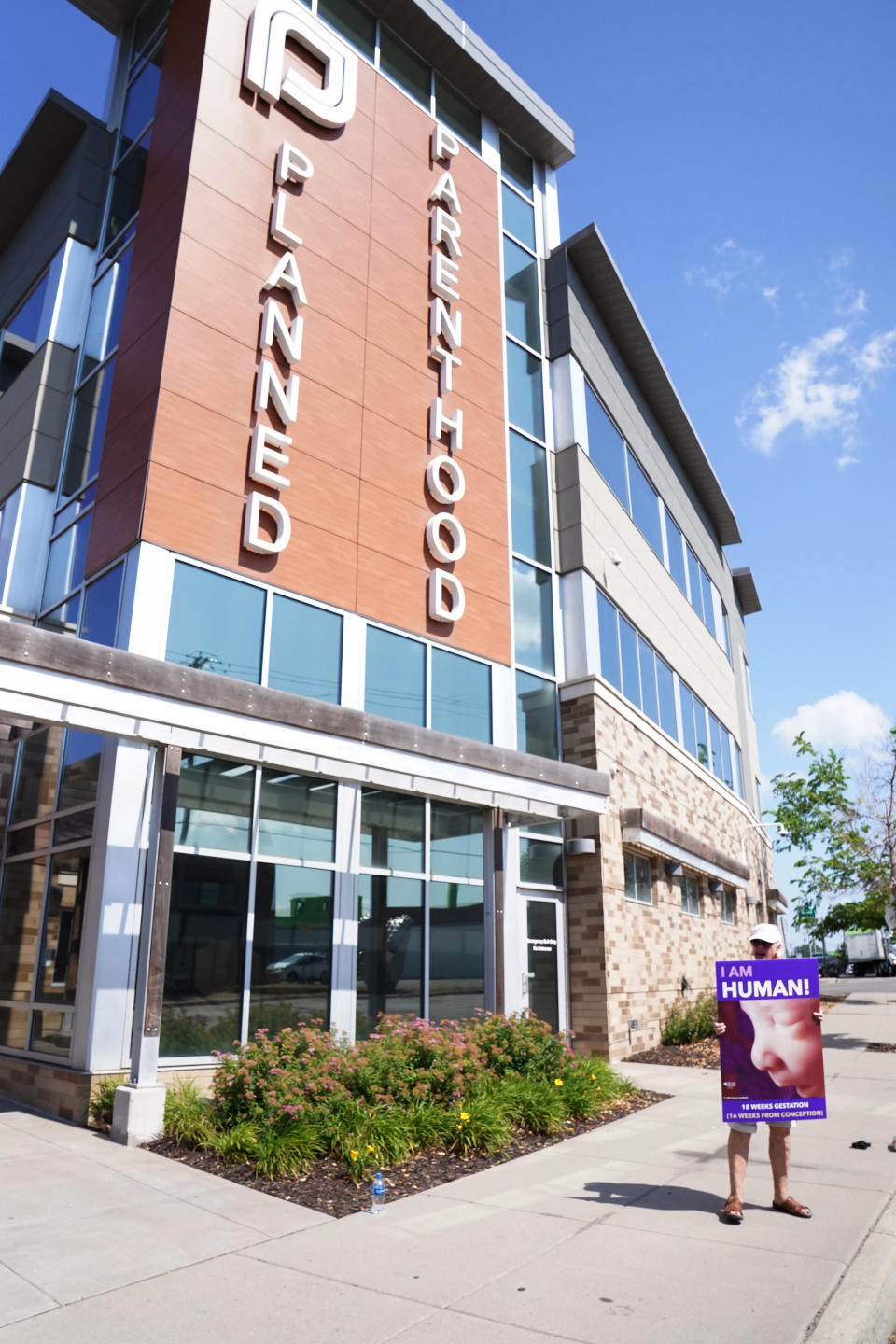 A protester demonstrates in front of a Planned Parenthood, Tuesday, July 12, 2022, in Saint Paul, Minn. A court ruling that struck down most of Minnesota's restrictions on abortion as unconstitutional will speed the process for clinics and patients, though providers are still studying all the implications of how the landscape will change as a result.(AP Photo/Abbie Parr)