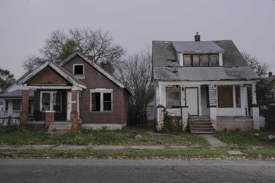 At left, a house owned by the Detroit Land Bank Authority and, at right, a vacant house owned by Covington and the Georgia Street Community Collective. The Land Bank required Covington to board up the house or possibly lose ownership, though the Land Bank has yet to board up this and other houses on the same block. (Photo: Sean Proctor for HuffPost)