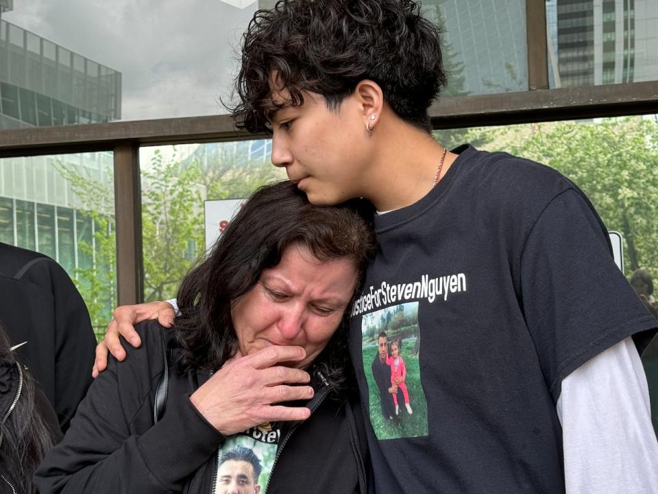 Maria Nguyen leans on her grandson Christian Nguyen as she speaks about her son, Steven Nguyen, who was shot and killed by a police officer in 2021.