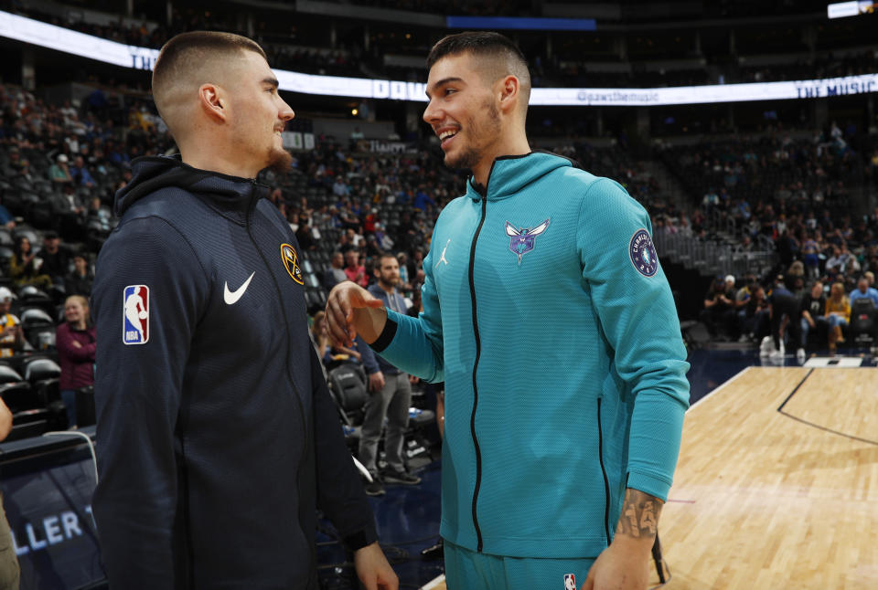 Denver Nuggets forward Juan Hernangomez, left, greets his brother, Charlotte Hornets center Willy Hernangomez before an NBA basketball game Saturday, Jan. 5, 2019, in Denver. (AP Photo/David Zalubowski)