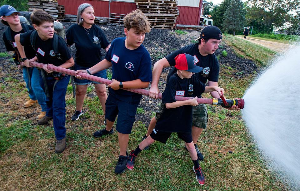 Lynn Kirkner, third from the left, a firefighter with the Hartsville Fire Company, in Warminster, on Wednesday, July 27, 2022, assists during the station's firefighters camp for teenagers.