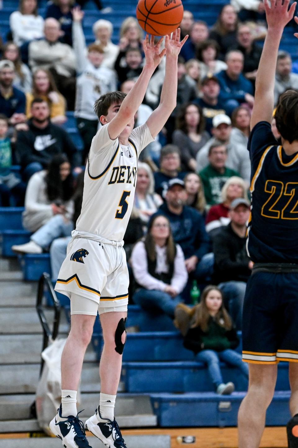 DeWitt's Zach Nevison, left, makes a 3-pointer as Grand Ledge's Alex Moran defends during the fourth quarter on Friday, Feb. 3, 2023, at DeWitt High School.