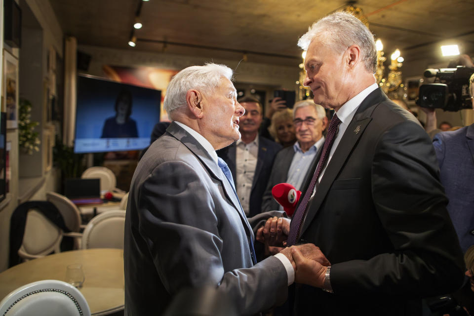 Former Lithuanian President Valdas Adamkus, left, is congratulated by Lithuanian President Gitanas Nauseda, a presidential candidate, after winning the second round of Lithuania's presidential election, in Vilnius, Lithuania, late Sunday, May 26, 2024. (AP Photo/Mindaugas Kulbis)