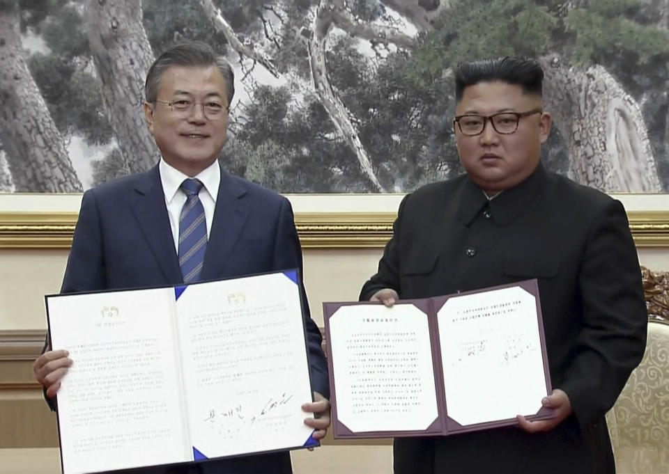 In this image made from video provided by Korea Broadcasting System (KBS), South Korean President Moon Jae-in, left, and North Korean leader Kim Jong Un pose after signing documents in Pyongyang, North Korea Wednesday, Sept. 19, 2018.(Korea Broadcasting System via AP)