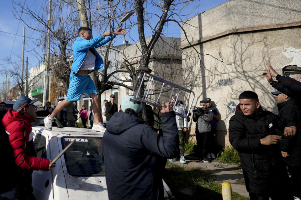 Un manifestante arroja una baldosa a la policía en una protesta por la muerte de Morena Domínguez, una niña de 11 años que murió en el hospital por los golpes que sufrió en un robo, a la afueras de Buenos Aires, Argentina, el miércoles 9 de agosto de 2023. (AP Foto/Natacha Pisarenko)