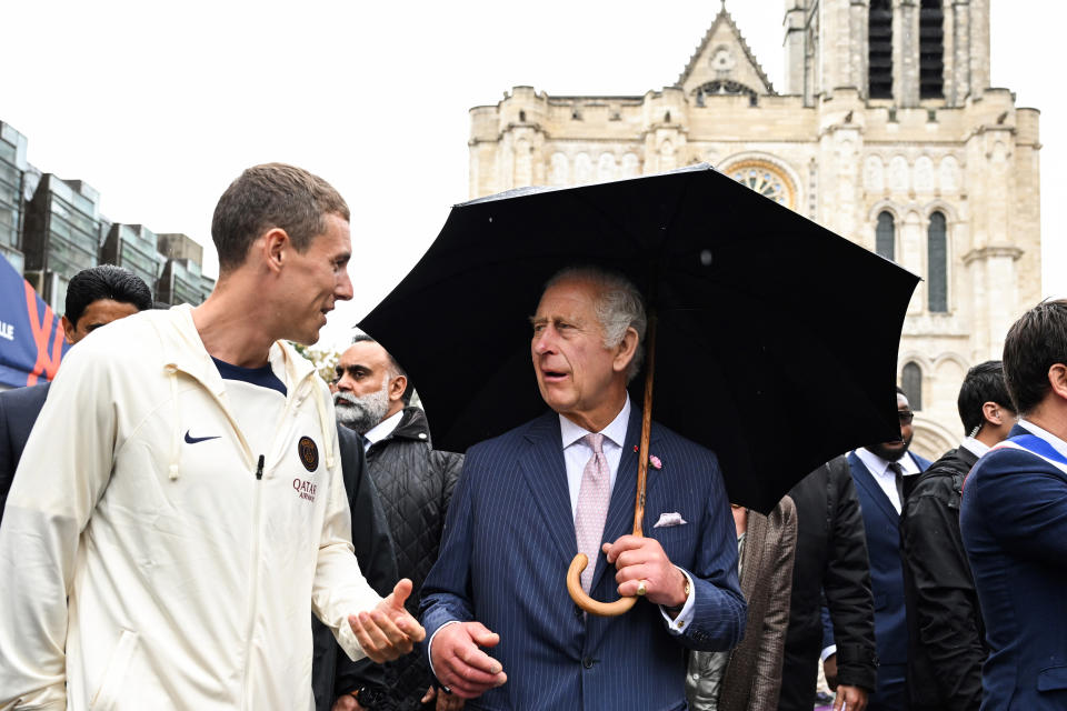 Britain's King Charles III speaks with a member of Paris Saint-Germain football club Foundation Thursday, Sept. 21, 2023 in Saint-Denis, outside Paris. On the second day of his state visit to France, King Charles met with sports groups in the northern suburbs of Paris and was scheduled to pay a visit to fire-damaged Notre-Dame cathedral. (Bertrand Guay, Pool via AP)