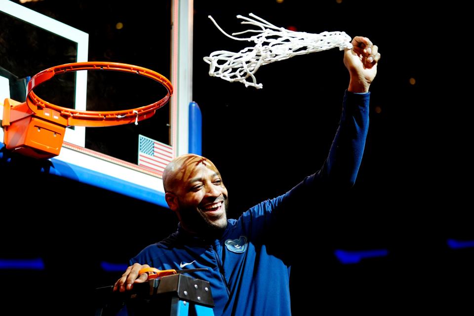 Xavier interim head coach Jonas Hayes cuts down the net after the Musketeers defeated Texas A&M in the NIT final.