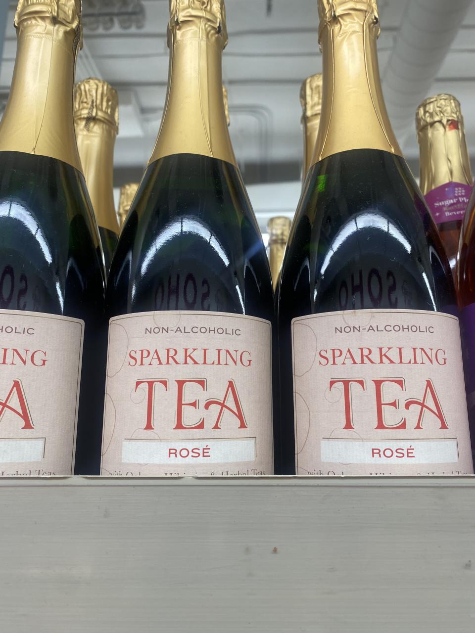 bottles of non-alcoholic rosé sparkling tea on a shelf