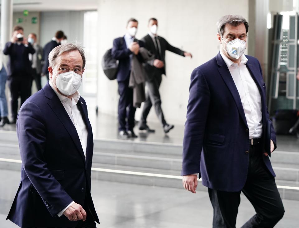 The chairman of the German Christian Democratic Party (CDU), ArminLaschet, left, and the chairman of the German Christian Social Union (CSU), Markus Soeder, right, arrive for a statement folowing a closed meeting of the federal palrliament factions of both partys in Berlin, Germany, Sunday, April 11, 2021. The two party chairmen and German state governors want to become the center-right candidate for the country's Sept. 26 national election, the German news agency dpa reported Sunday. (Michael Kappeler/dpa via AP)