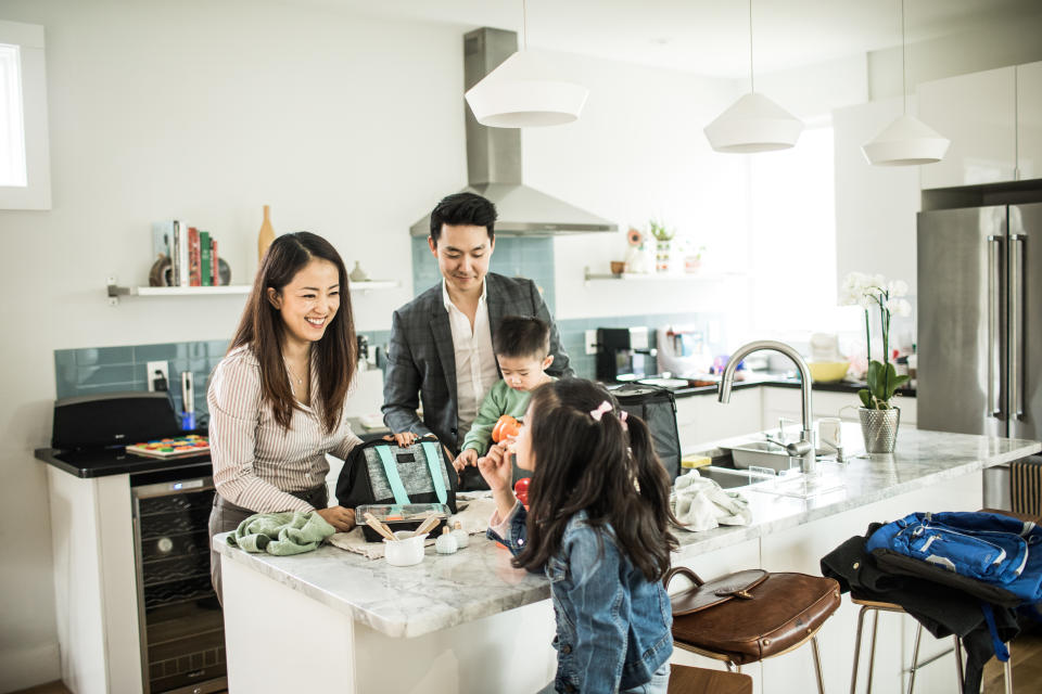 Working parents packing lunches for children