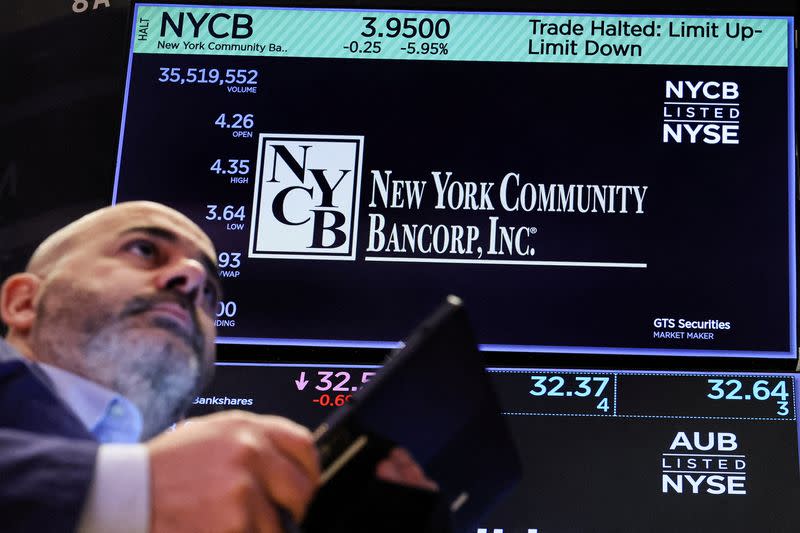 FILE PHOTO: A trader works at the post where New York Community Bancorp stock is traded on the floor at the NYSE in New York