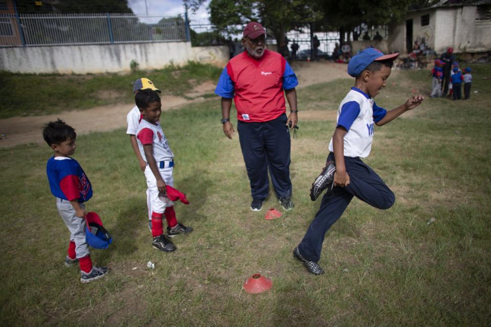 In this Aug. 12, 2019 photo, coach Nelson Castro watches his young charges perform agility drills at Las Brisas de Petare Sports Center, in Caracas, Venezuela. "It's sad to see that the number of boys attending has dropped a lot," said 58-year-old trainer, who has coached for decades and shaped future stars. (AP Photo/Ariana Cubillos)